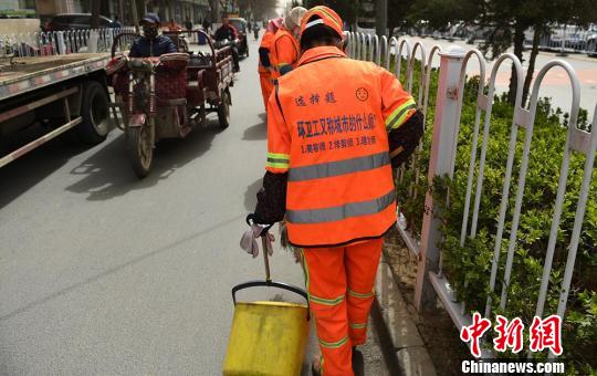 马甲的背部采用“一个问题，三个选项”的形式，环卫工穿上它便成为寓教于乐为一体的“行走的考卷”，并且这30余道选择题都是他们集思广益想出来的?！⊙钛廾?摄