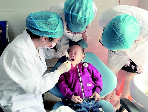 牛忠英委员（左一）在义诊中。    本报记者  蔡鎏  摄