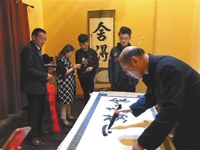 一名被冠以“一级书法大师”的男子正在现场挥毫卖字。 点击进入下一页