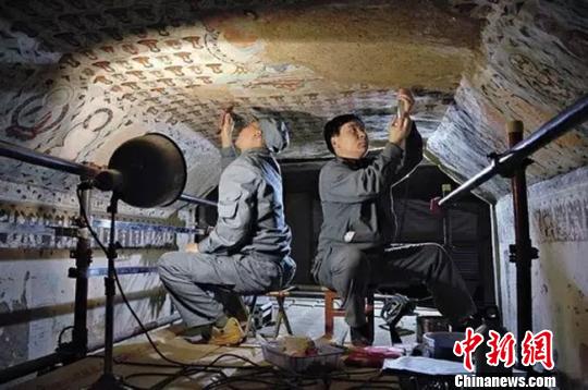 图为敦煌守护者在修复壁画。敦煌研究院供图 摄