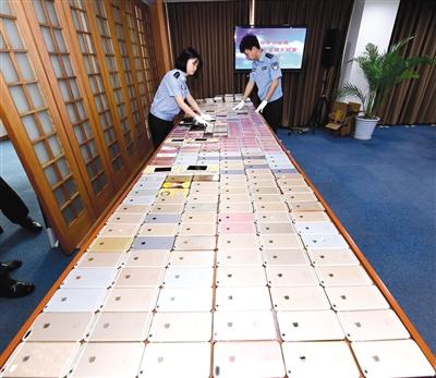 北京警方破获特大盗销手机团伙，起获的525部被盗手机铺满了一张大桌子，其中大多是苹果手机。	警方供图