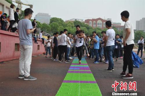 背“娃娃”大闯关项目旨在让男生体验母亲背孩子行走的艰难 吴楠馨 摄 背“娃娃”大闯关项目旨在让男生体验母亲背孩子行走的艰难 吴楠馨 摄