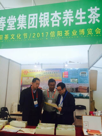 5、来自全国各地的茶商积极参加第25届信阳茶文化节展览展示。图为来自山东省济宁市永春集团的参展商在研究推展措施。  梓涵  摄影