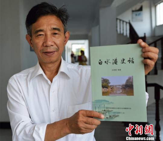 沈明星和他编著的《白水港史话》 冉德强 摄 沈明星和他编著的《白水港史话》 冉德强 摄