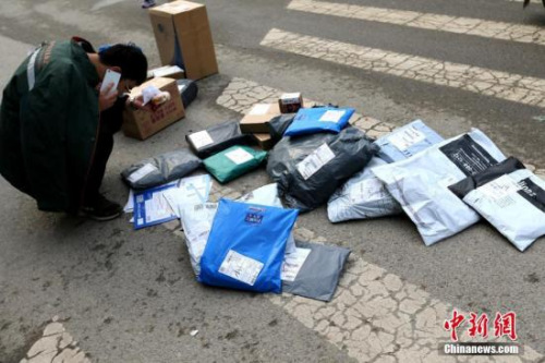 资料图：快递员在打电话联系买家。<a target='_blank' href='http://www.chinanews.com/'>中新社</a>记者 张远 摄