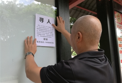 徐长生(化名)在街头张贴寻人启事 徐长生(化名)在街头张贴寻人启事