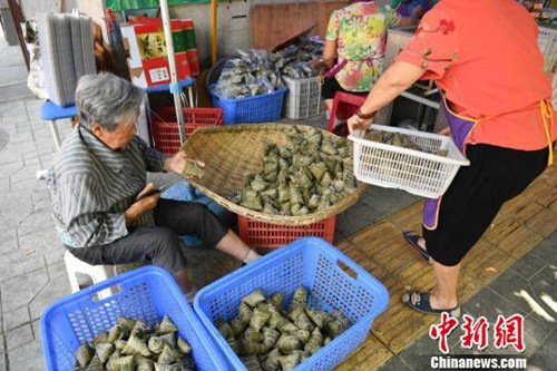 资料图：一位老人正在包粽子。张浪 摄