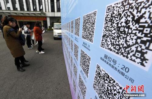 资料图：一些求职者在招聘会现场扫二维码查询工作岗位。 张斌 摄 (图文无关)