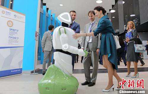 当地时间6月1日，几名与会者在与展出的人形机器人进行交流。 <a target='_blank' href='http://www.chinanews.com/'>中新社</a>记者 王修君 摄