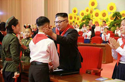 金正恩佩戴红领巾与儿童互动。