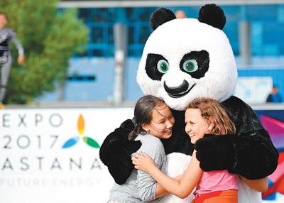 中国侨网图为5日，当地儿童与舞蹈团中代表中国元素的熊猫卡通形象互动。  　　新华社记者  吴晓凌摄