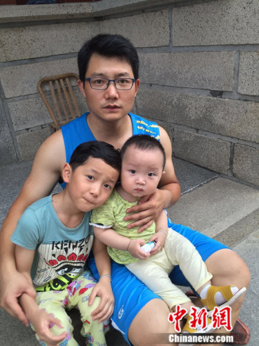 图为二孩“奶爸”和两个可爱的孩子。吕春荣 摄