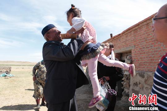 图为张义兵的阿爸将汉族孙女高高举起。　樊晓丽 摄