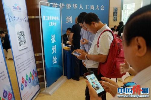 第二届华侨华人工商大会报到现场，中国新闻社“侨宝”客户端及中国侨网微信宣传品吸引了高度关注，嘉宾纷纷扫码下载。付强 摄