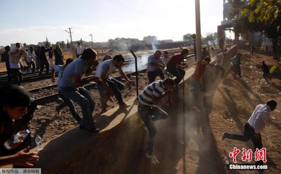 当地时间9月26日，土耳其Suruc，在叙利亚与土耳其边境再次发生动乱。大批叙利亚境内的库尔德难民及士兵在土耳其库尔德人的帮助下，拆毁两国国境之间的隔离墙强行进入土耳其。