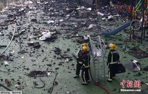 图为消防员在瓦砾中行进。