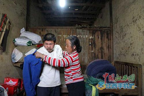 吴果英正在给养子范百孙穿衣 点击进入下一页