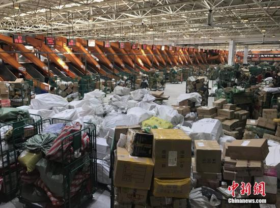 1月20日，湖南长沙邮区中心局的工作人员正在处理堆积的快递包裹。随着中国春节的临近，为了避开实体店购物的拥挤和繁琐，越来越多的人选择网络购置年货，快递行业也随之迎来“春运”高峰。<a target='_blank' href='http://www.chinanews.com/'>中新社</a>记者 唐小晴 摄