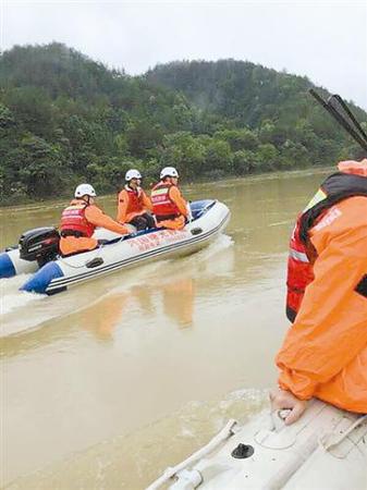 江西兴国曙光救援队在河里搜救。本报记者 何深宝摄