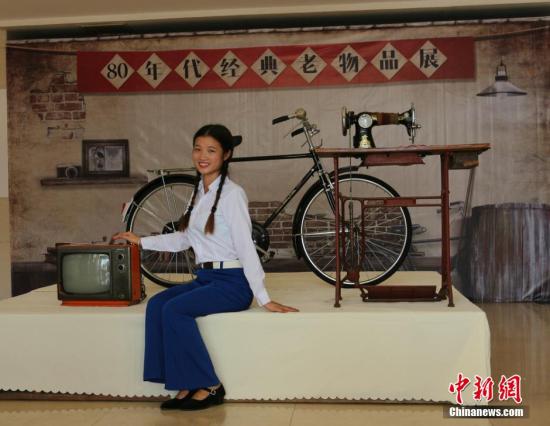 资料图 图为工作人员展示80年代的居家三件套： 永久自行车、黑白电视机、缝纫机 黄诗立 摄