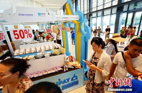 资料图：某消费者在线下商品展台前选购。