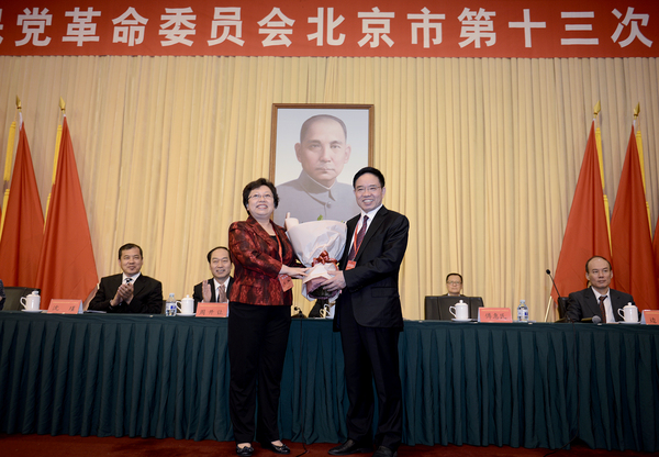 民革北京市第十五届委员会主任委员王红向民革北京市第十四届委员会主任委员傅惠民鲜花。17