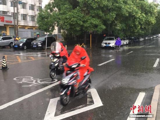 6月23日清晨，北京降雨持续，并出现了短时大雨。据北京市气象局官方微博消息，北京市气象台今日6时发布：今天白天小到中雨并伴有雷电，傍晚局地伴有短时大风或冰雹，北转东风2、3级，最高气温24℃；夜间有雷阵雨，东转北风2、3级，最低气温19℃。图为北京阜成路，市民雨中骑行。 <a target='_blank' href='http://www.chinanews.com/' >中新网</a>记者 富宇 摄