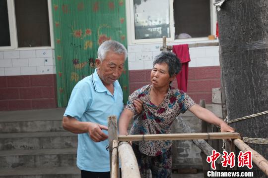 为让妻子慢慢学会走路，李文生每天扶着妻子一遍一遍练习走路?！±钤汉?摄