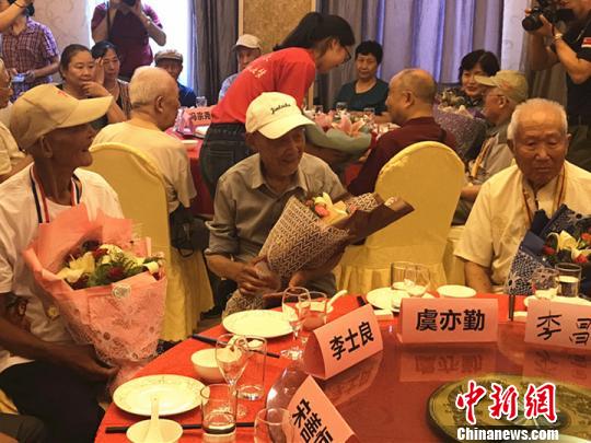 志愿者为抗战老兵献上鲜花?！⊙钛沾?摄