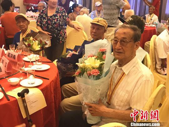 抗战老兵手捧鲜花?！⊙钛沾?摄