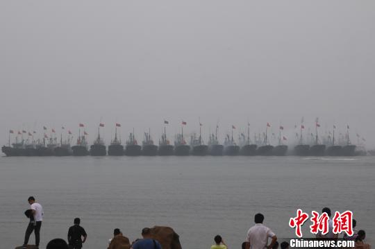 当地渔民驾驶着挂满红绸的渔船开启祭海巡游，驶向主祭坛所在地——海上碑龙王庙?！≌盼髦?摄