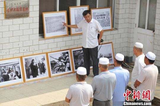 图为赵文岭在影展上向参观者介绍影展展出内容。　苑立伟 摄