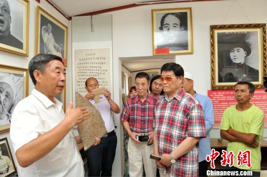 图为赵文岭(左)在影展上向马本斋之子、海军航空兵原副政委马国超(右二)介绍影展中陈列的实物?！≡妨⑽?摄