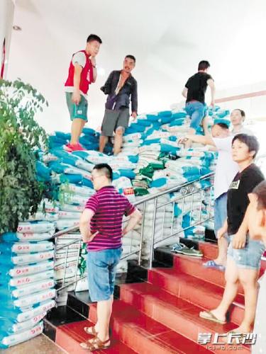 在宁乡救灾一线，一位“独臂大叔”用左手搬运大米，感动了不少人。 长沙晚报通讯员 杨欣 摄 