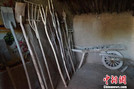 何世前的农家小屋里，整齐地陈列着年代不种的农具和生活用品?！〕滤?摄