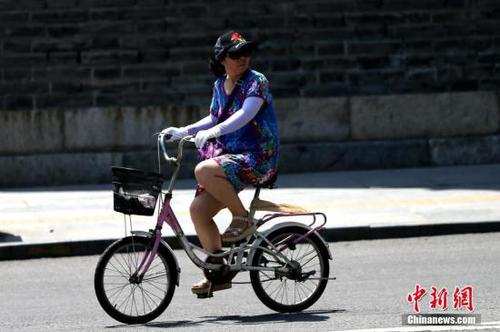 7月11日，陕西民众在烈日下出行。当日，陕西省气象台升级发布高温红色预警信号，未来24小时陕西大部分地区将出现37℃以上高温天气，局部地区将达40℃以上，未来四天还将会出现今年以来最强高温天气。 <a target='_blank' href='http://www.chinanews.com/'>中新社</a>记者 张远 摄