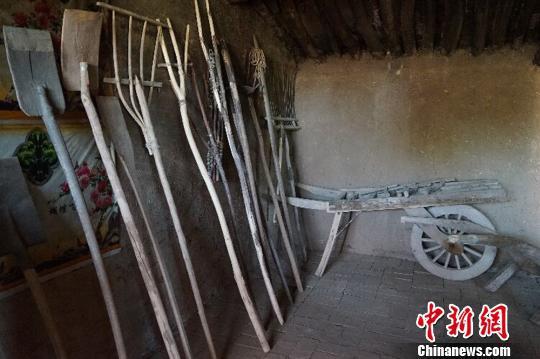 何世前的农家小屋里，整齐地陈列着年代不种的农具和生活用品?！〕滤?摄