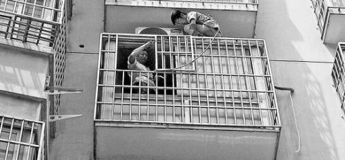 安装空调的师傅在4楼窗户边安装空调 安装空调的师傅在4楼窗户边安装空调