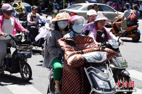 7月10日，福建省福州市民出行“全副武装”抵挡酷暑。 刘可耕 摄