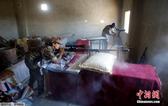 当地时间2017年6月18日，叙利亚拉卡，库尔德武装继续在拉卡推进，围剿极端组织。图为两名库尔德武装的女兵在掩体中配合，对极端分子进行狙击。