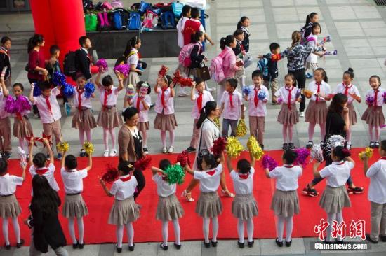 9月10日是一年一度的教师节。9月9日，山西太原新建路小学的教师们在学生们的欢呼簇拥下像明星一样走红毯展风采、秀签名，并接受他们崇高的敬礼与祝福。图为孩子们夹道欢迎老师走红毯展风采。张云 摄