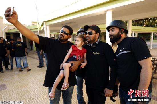 资料图为利比亚班加西摩托车手在穆斯林斋月期间看望孤儿院的儿童，并为他们带去礼物。