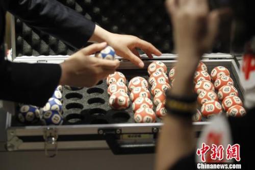 图为特制的开奖号码球，每个球重24克，价值1500元?！≈芫?摄