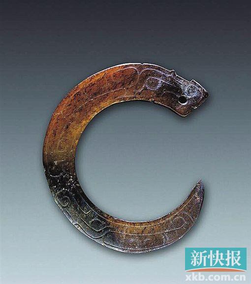 曲体玉龙 西周 陕西省长安县普渡村出土。器呈黄褐色，造型为“c”字形。头部较大，长眉，椭圆形长梢眼，口微张，鼻向上勾卷，器身弯曲状，由粗变细，尾呈尖状，向上勾卷，器身阴刻勾连云纹、眼目纹、二字纹等，口部镂空一小孔。此器造型是商代卷体玉龙的延续，但造型趋于平面化，背少雕脊齿，纹饰中少见重回纹及雷纹。相比商代，周代早期玉龙在雕刻技法和纹饰上有所变化。玉龙的嘴部、唇上翘并有角度。周初龙角也比商代小，但根部较大，躯体比商代瘦长，纹饰也较复杂化。西周中晚期，身躯更细长，无角，代替龙角的是花叶形耳朵，东周时出现卷云形耳。周代玉龙大多不雕刻腿和足。