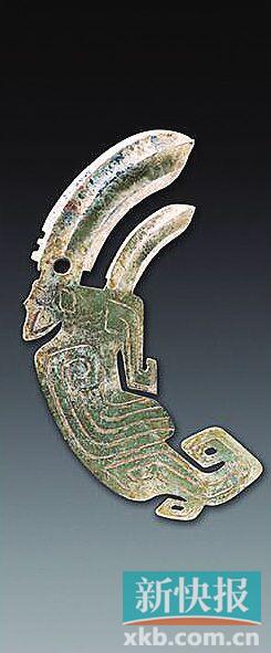 凤鸟形内双援玉戈 商 青玉，体扁平。凤鸟冠雕刻一大一小弯弧形援戈，中间有脊锋，前锋呈三角形，尖锐，两侧带刃，大援下部有扉棱和穿孔，可佩系。内为凤鸟身。凤鸟头后有角，棱形眼，尖喙，双翅并拢，尾部向上卷起，爪呈钩状，尾、足各有镂孔。翅膀用阴线雕刻，羽翎纹，两面纹饰相同。