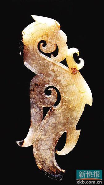 玉凤鸟佩 战国中期 河南省辉县固围村二号墓出土。器呈白色，上有黑色沁斑，尾端稍有残缺。体扁平，两面透雕成凤鸟形状，身成“s”形。俯首，张口，尖喙较长，并向内勾卷。圆圈形目，头顶有冠，身体较长，胸前部伸出一爪，较锋利，呈抓握状。背部雕有翅羽纹，分成两叉，一长一短，均向上呈卷曲状。尾部下垂。器身阴刻云纹、曲线纹等。战国时期，雕刻有大量的精美龙形佩饰，此器的造型与龙形佩有相似之处，但在喙、冠、翅、爪及纹饰上又有着独特韵味，更显生动鲜活。