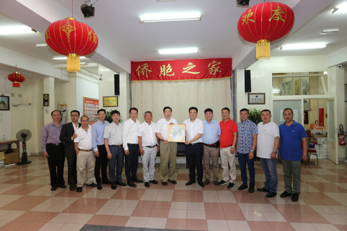 冯志农向法国华侨华人会赠送纪念品。