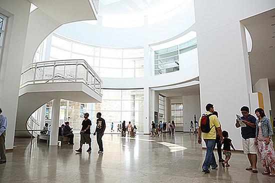 阳光透过博物馆入口大厅的玻璃外墙照射进来，为室内提供照明。