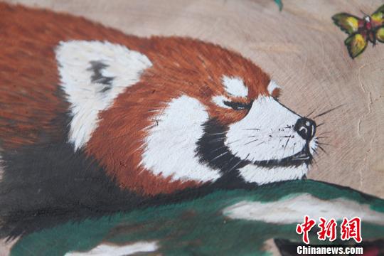 图为珞碧迈创作的4副“嘟嘟”圆木板画像?！≈有?摄