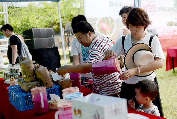 22.各地来到集旅游和休闲结合的大丘庄园游览的游客，在这里品尝火龙果汁。jpg